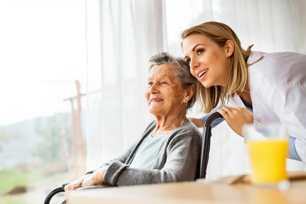 A caregiver and patient sharing a warm moment by a sunlit window