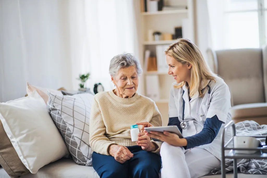A healthcare worker helping a patient with medication at home