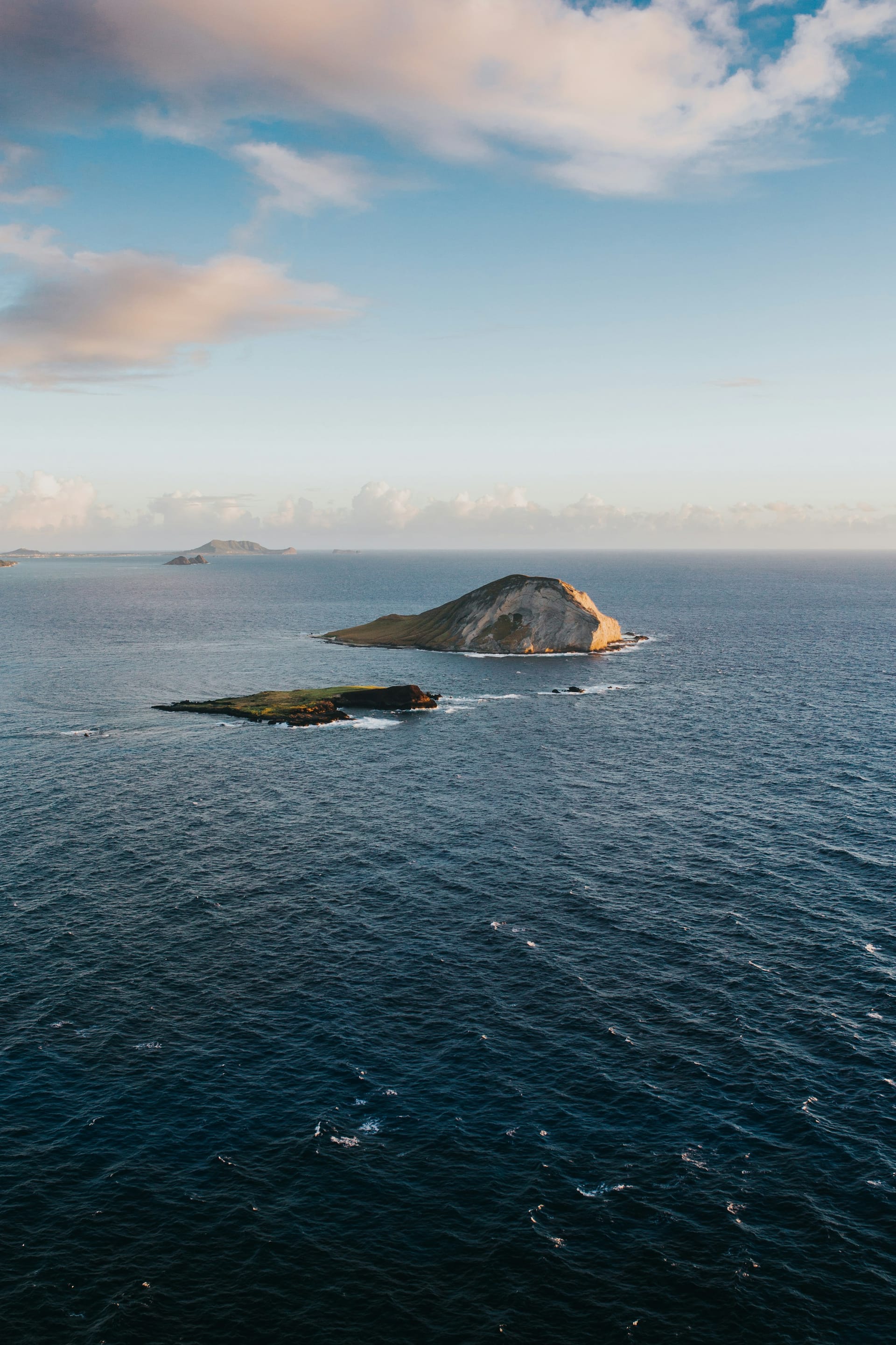 Distant Pacific islands silhouetted across calm coastal water