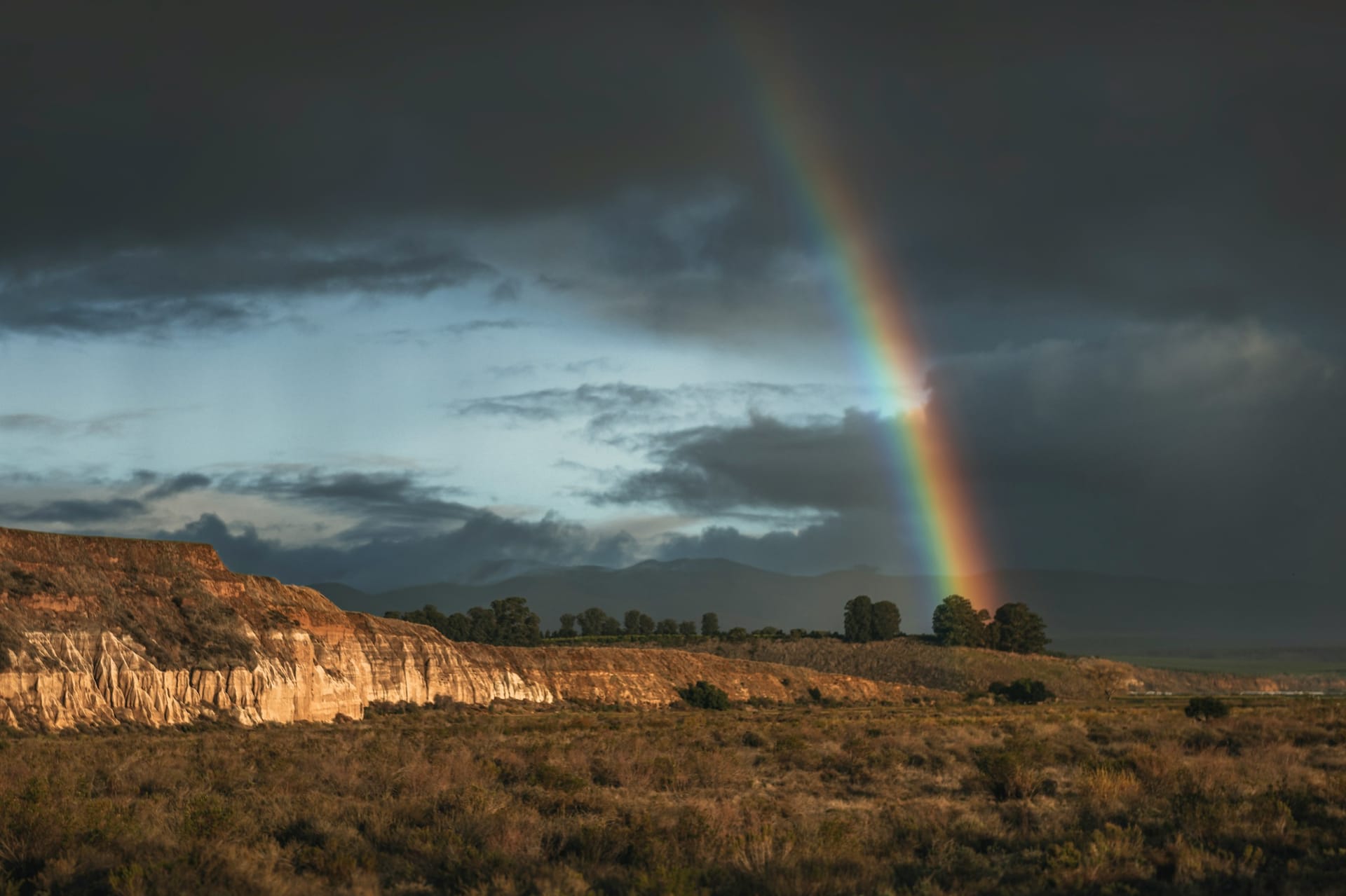 A rainbow arcing over a mountain ridge after rain